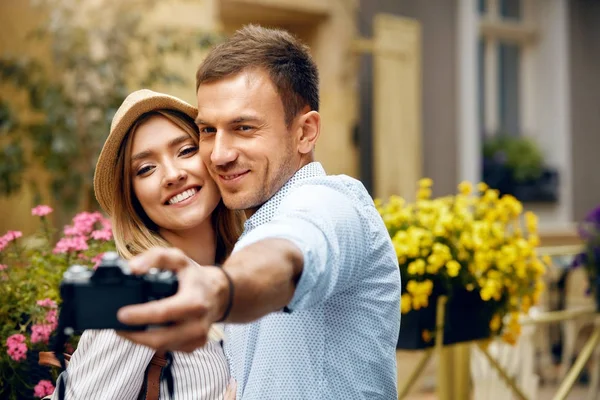 Hermosa pareja tomando fotos con cámara en la calle . — Foto de Stock