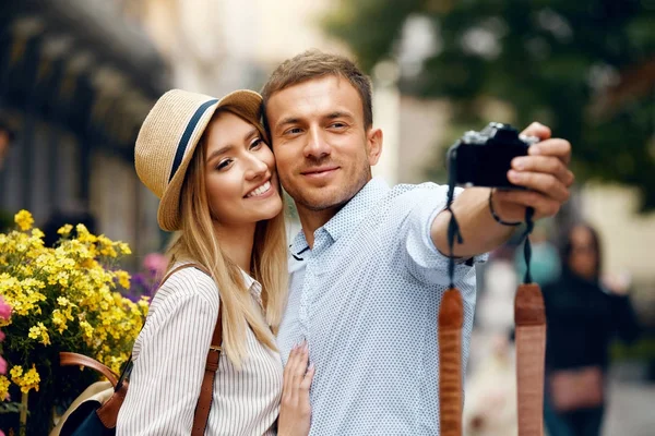 Casal bonito tirando fotos com câmera na rua . — Fotografia de Stock