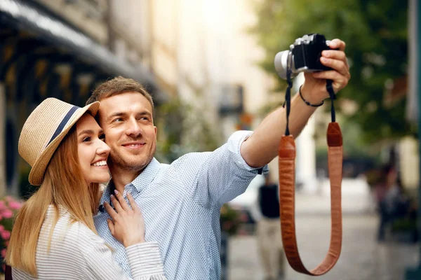 Hermosa pareja tomando fotos con cámara en la calle . —  Fotos de Stock