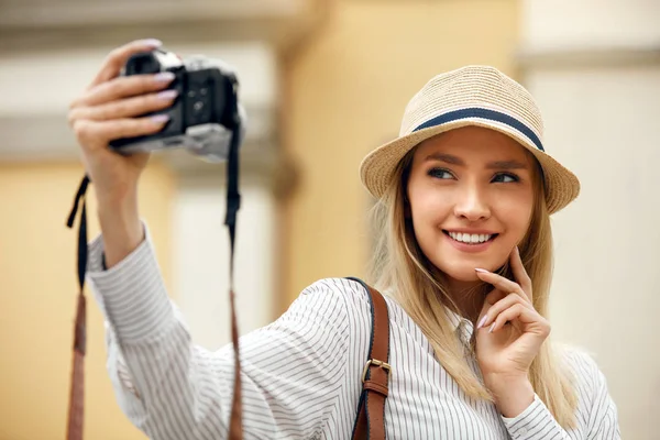 Schönes glückliches Mädchen, das Fotos vor der Kamera macht. — Stockfoto