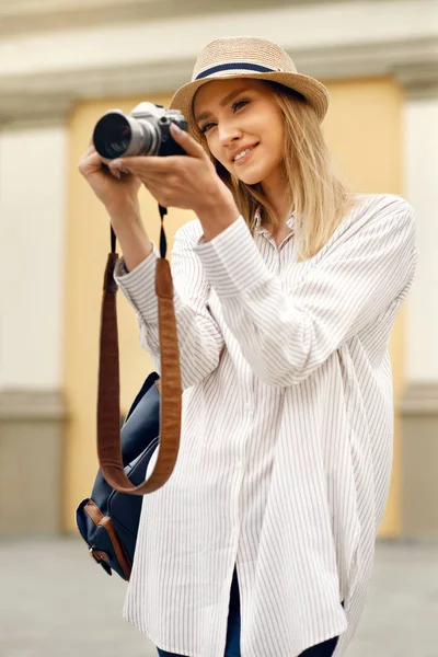 Touristenmädchen mit Kamera fotografiert auf der Straße. — Stockfoto