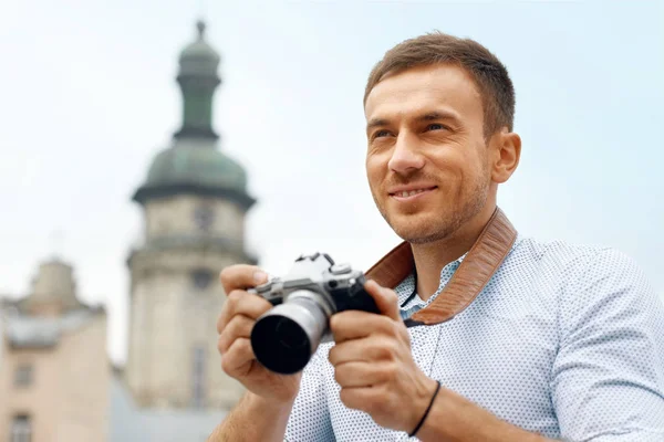 Mężczyzna fotograf fotografowania w aparacie na ulicy — Zdjęcie stockowe