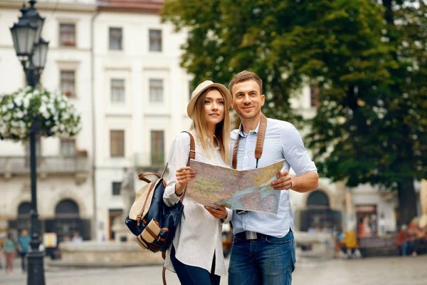 Τουριστική ζευγάρι με χάρτη περπάτημα σε δρόμο της πόλης. — Φωτογραφία Αρχείου