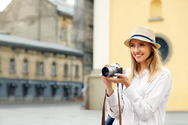 Fille touristique avec appareil photo prenant des photos sur la rue . — Photo