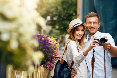 Sokakta fotoğraf makinesinde turist çift alarak fotoğraf.