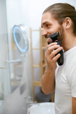 Adam aynaya bakmak yüz tıraş.