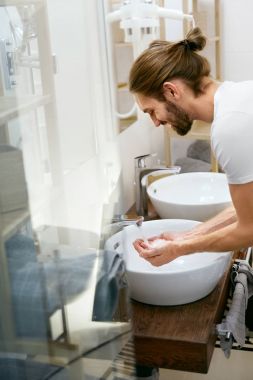 Adam yüz yıkama. Genç erkek yüz banyo temizliği.