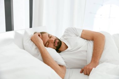 Sabah yatakta uyuyan adam.