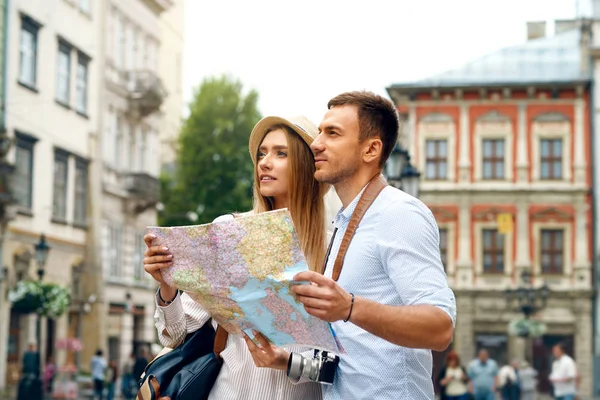 Τουριστική ζευγάρι με χάρτη περπάτημα σε δρόμο της πόλης. — Φωτογραφία Αρχείου