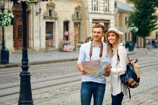 Casal de turistas com mapa andando na rua da cidade . — Fotografia de Stock