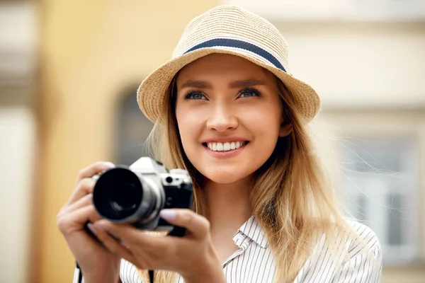 Женщина фотографирует на камеру на улице — стоковое фото