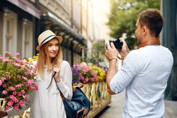 Pareja de turistas. Hombre con cámara tomando fotos de mujer en la calle — Foto de Stock