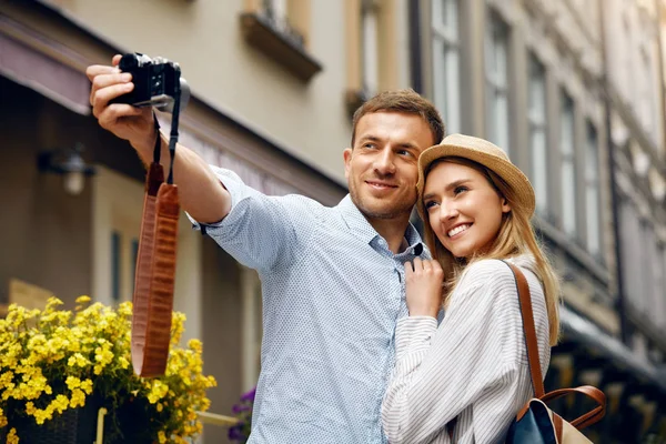 Pareja de turistas enamorados tomando fotos durante el viaje . — Foto de Stock