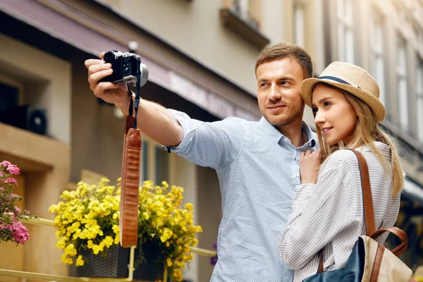 Pareja de turistas enamorados tomando fotos durante el viaje . — Foto de Stock