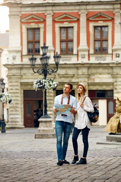 Casal de turistas com mapa andando na rua da cidade . — Fotografia de Stock