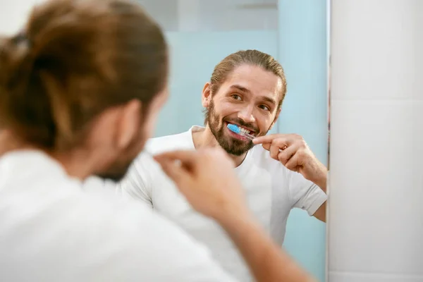 Człowiek szczotkowanie zębów. Mężczyzna czyszczenia zębów w łazience. — Zdjęcie stockowe