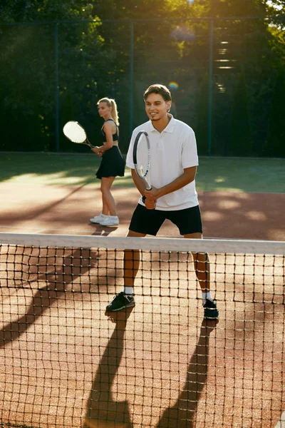 Man en vrouw tennissen op het veld. — Stockfoto