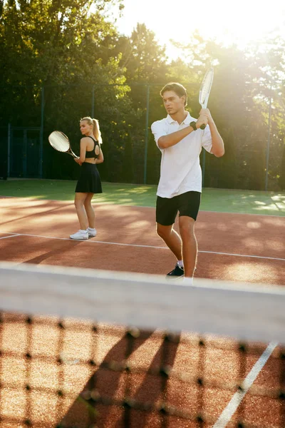 Homem e mulher jogando tênis na quadra. — Fotografia de Stock