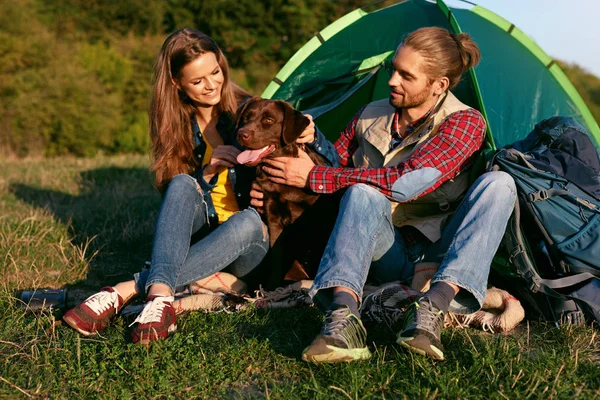 Hombre y mujer viajando con perro en el campamento — Foto de Stock