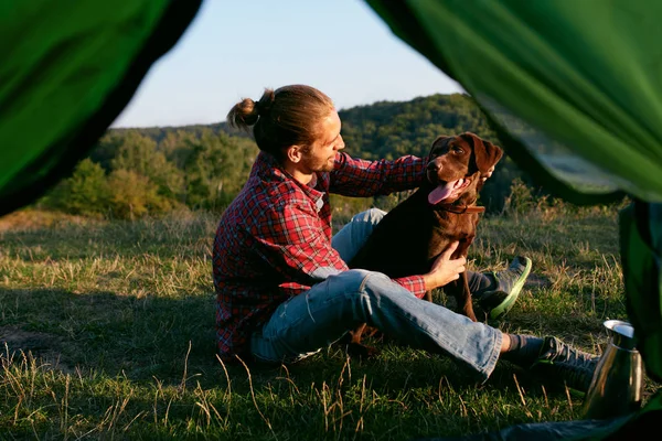 Hombre viajando con perro, acampando en la naturaleza. — Foto de Stock
