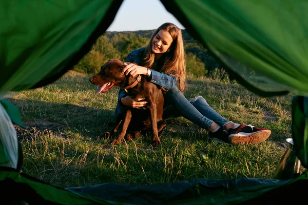 Acampar. Mujer feliz viajando con perro en la naturaleza — Foto de Stock