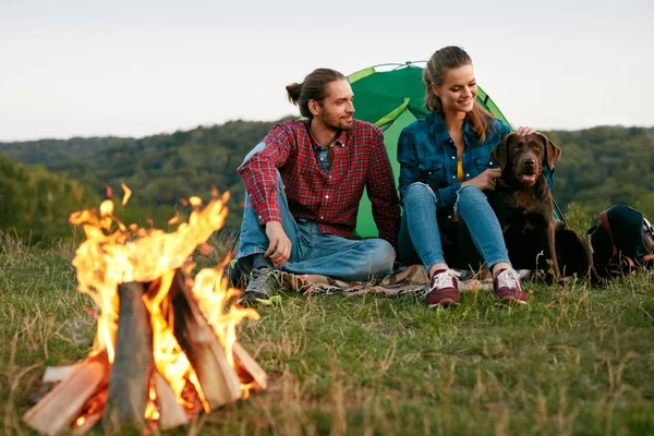 Hombre y mujer viajando con perro en el campamento — Foto de Stock