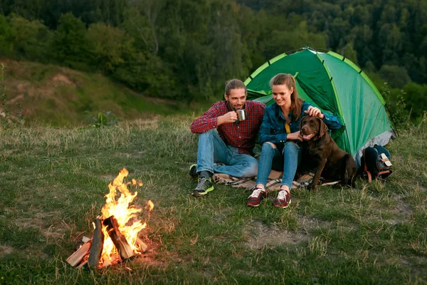 Hombre y mujer viajando con perro en el campamento — Foto de Stock