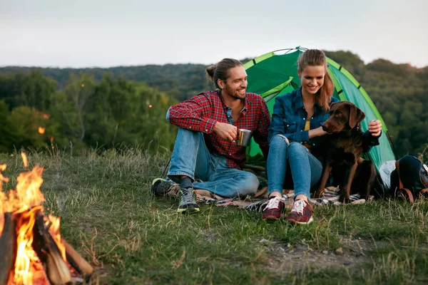 Hombre y mujer viajando con perro en el campamento — Foto de Stock