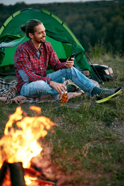 Man Traveling In Nature, Sitting Near Camp With Phone — Stock Photo, Image