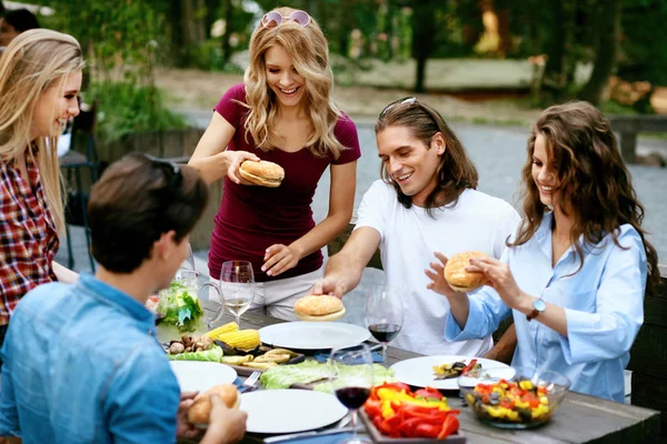 Pessoas comendo alimentos saudáveis em festa ao ar livre. Amigos — Fotografia de Stock