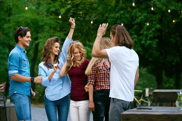 Amigos felizes dançando, se divertindo e desfrutando de festa ao ar livre . — Fotografia de Stock