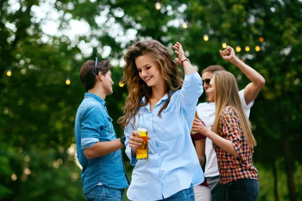 Девушка танцует с друзьями на вечеринке под открытым небом . — стоковое фото