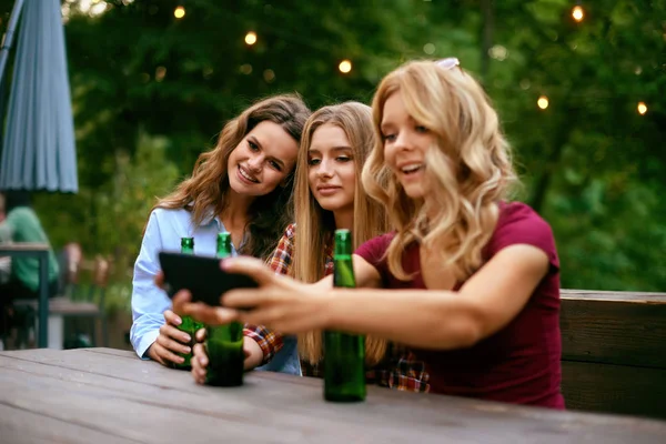 Друзья пьют пиво и фотографируют по телефону — стоковое фото