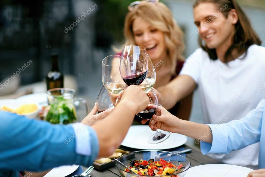 People Cheering With Drinks At Outdoor Dinner Party