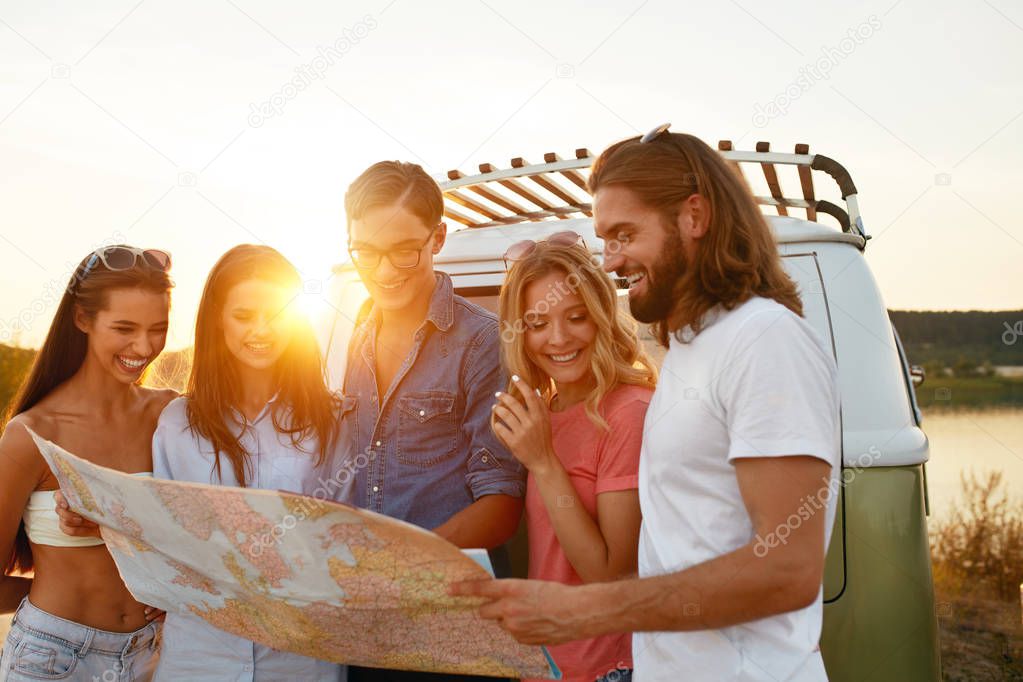Summer Travel. Friends Using Map Near Car In Nature