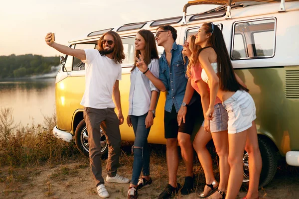 Amigos tomando fotos por teléfono en la naturaleza en verano — Foto de Stock