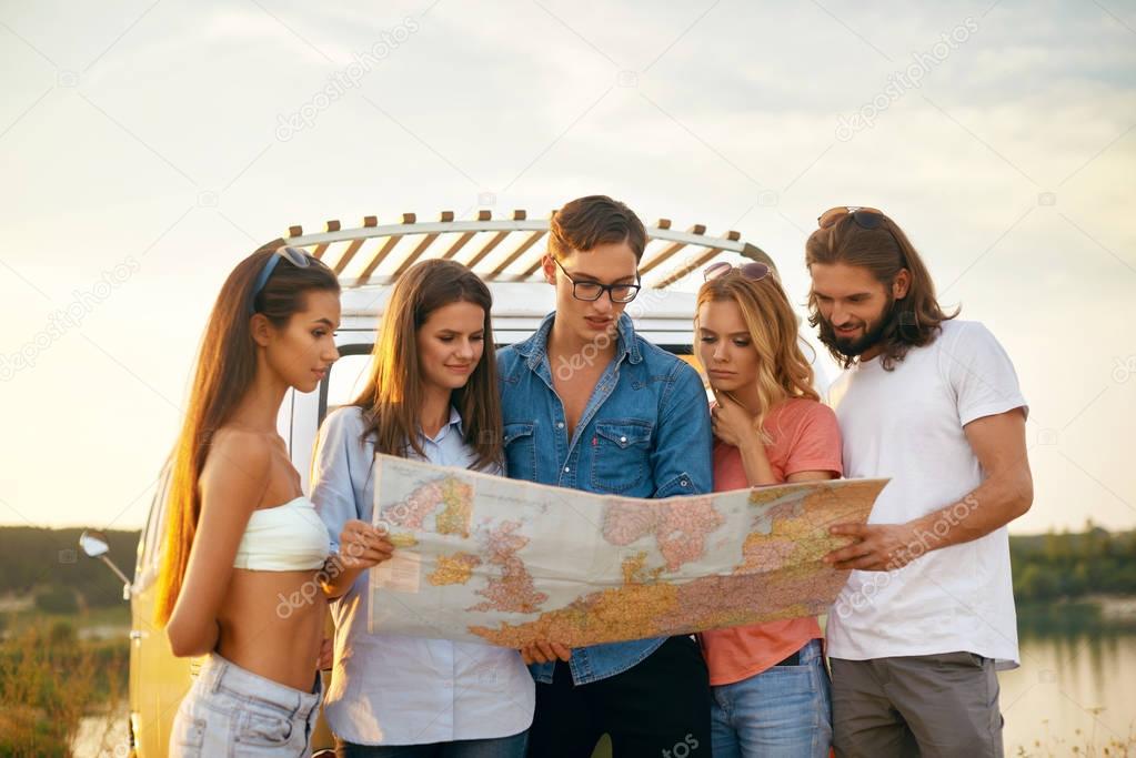 Summer Travel. Friends Using Map Near Car In Nature