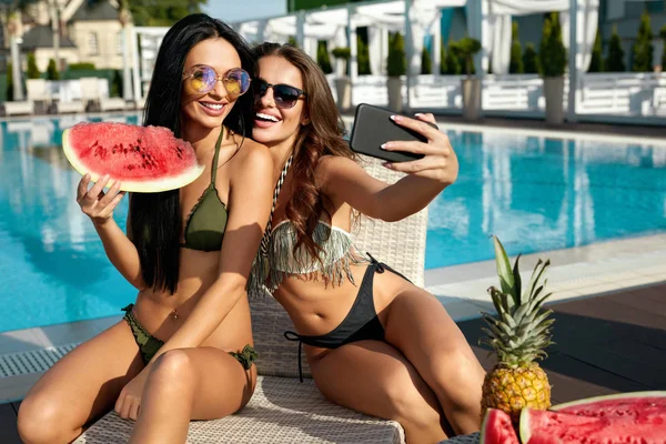 Moda de verano. Chicas divirtiéndose tomando fotos cerca de la piscina . —  Fotos de Stock