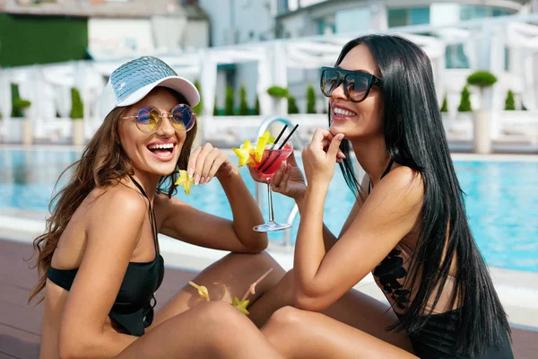 De pret van de zomer. Modieuze meisjes Cocktails drinken in de buurt van zwembad. — Stockfoto