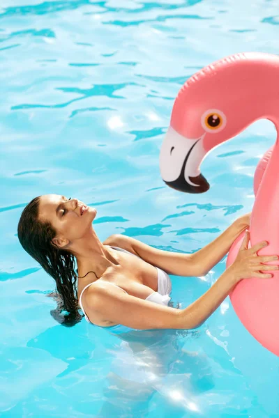 Moda de verano. Hermosa chica en la piscina con flamenco — Foto de Stock