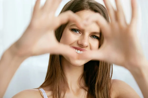Mooi meisje hart met handen tonen — Stockfoto