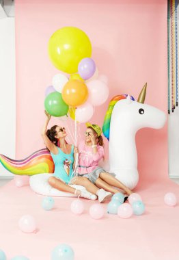 Tek boynuzlu at üzerinde balonlarla eğleniyor yaz moda kızlar Float