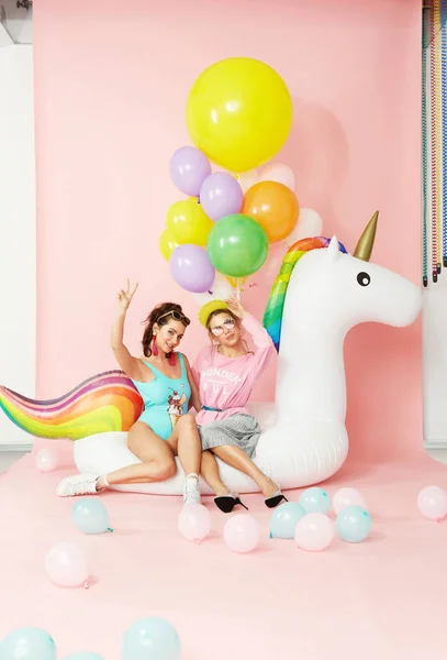 Verano moda niñas tener diversión con globos en unicornio flotador — Foto de Stock