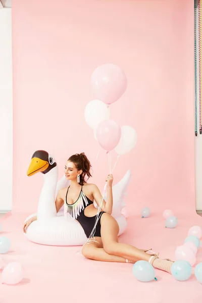 Στυλ του καλοκαιριού. Γυναίκα με μαγιό με μπαλόνια και πισίνα που επιπλέει — Φωτογραφία Αρχείου