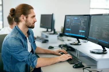 Programming. Man Working On Computer In IT Office clipart