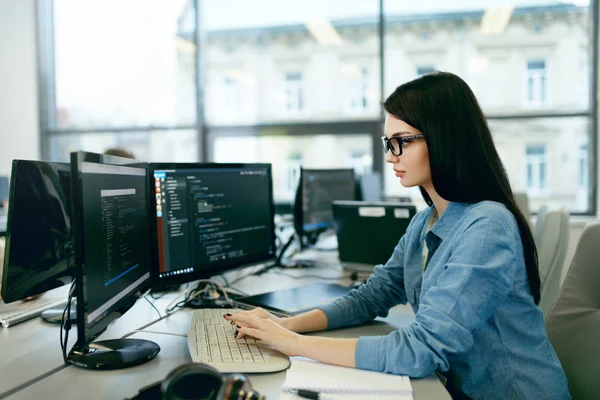 Mujer joven trabajando y programando en la computadora en la oficina . — Foto de Stock