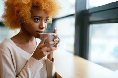 Güzel kız pencere yakınındaki Cafe kahve içme.