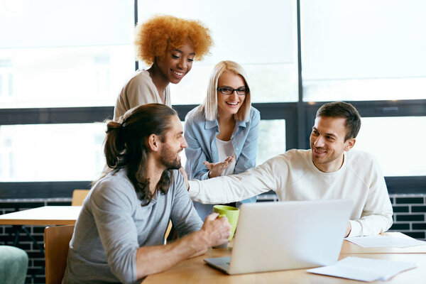Team Of People Working On Notebook In Cafe