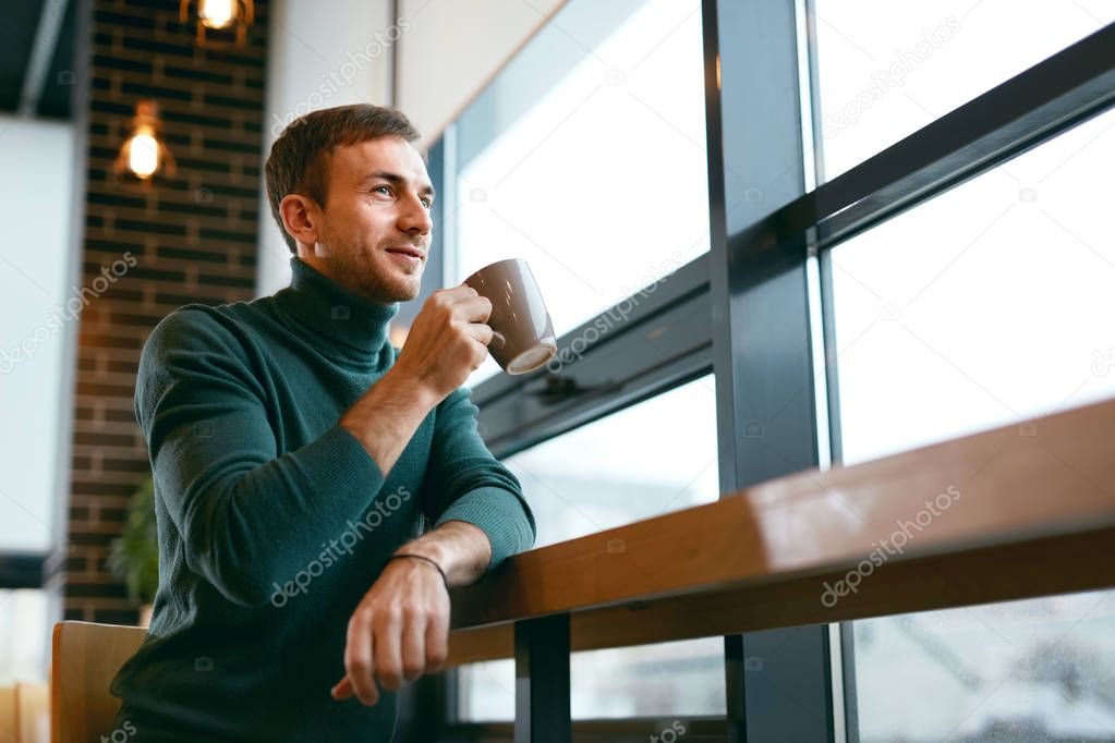 Man Drinking Coffee Drink In Cafe Near Window