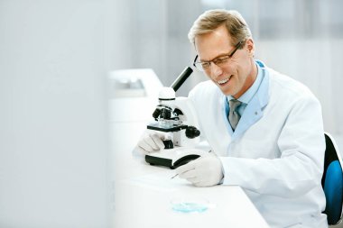 Laboratuar mikroskobu ile klinik test bilim adamı.